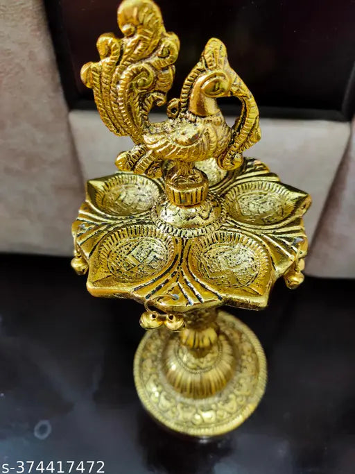 Golden peacock designer diya metal stand, intricately detailed Indian metalwork stand for traditional diyas
