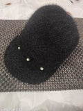 Black hat with black earrings, featuring a beanie style cap