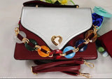Spacious sling bag with two partitions made of synthetic leather. Patterned in maroon and white colors