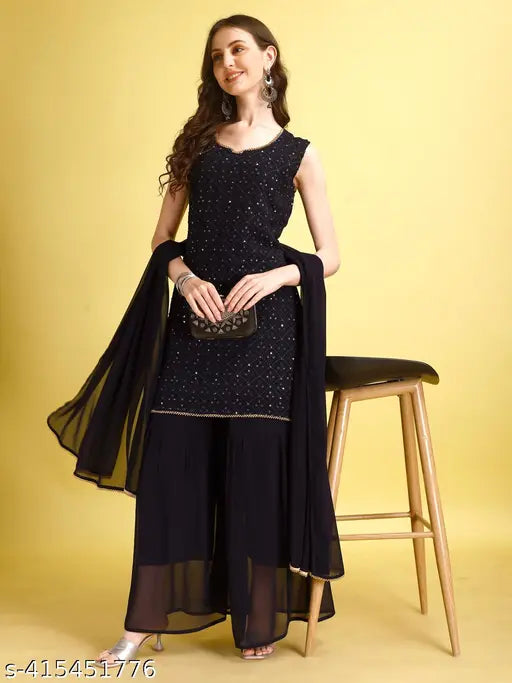 Black embellished sari with dupata, styled on a wooden stool