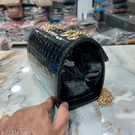 Black sling purse with a heavy shoulder chain