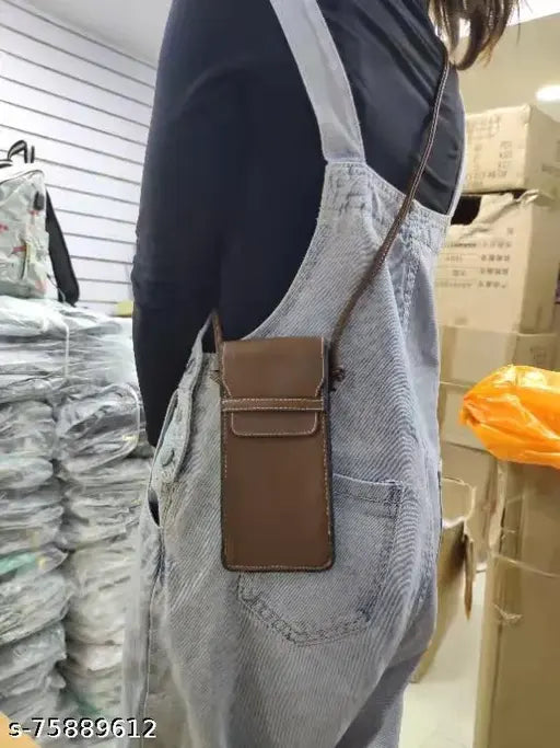 Brown leather pouch attached to a pair of blue denim overalls