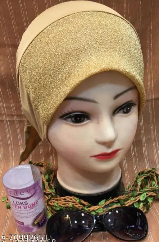 Gold and beige hijab cap with black sunglasses behind it