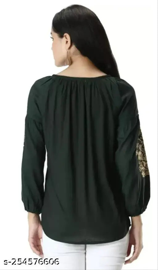 Green women's flared kurta with orange embroidery, three-quarter sleeve, viscose rayon. Close-up of ribbed fabric and border embroidery detail