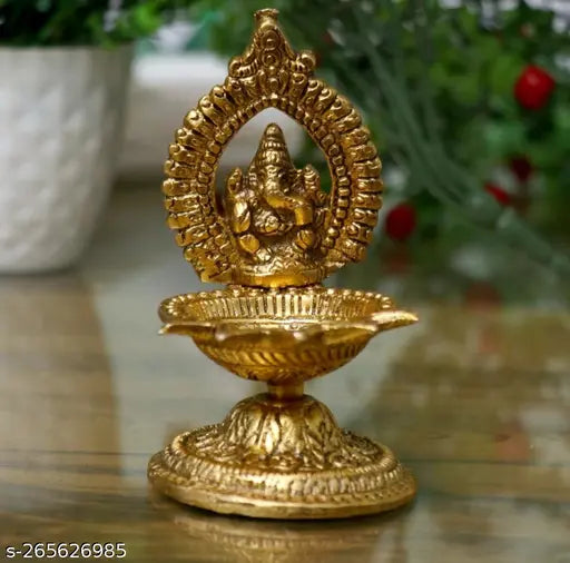 A set of metal table lamps in a traditional Indian style, featuring an idol of Lord Ganesha as the central motif on each lamp. The lamps have a metallic base and are designed with a single wick