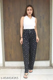 A woman wearing a white top and black pants with visible polka dots