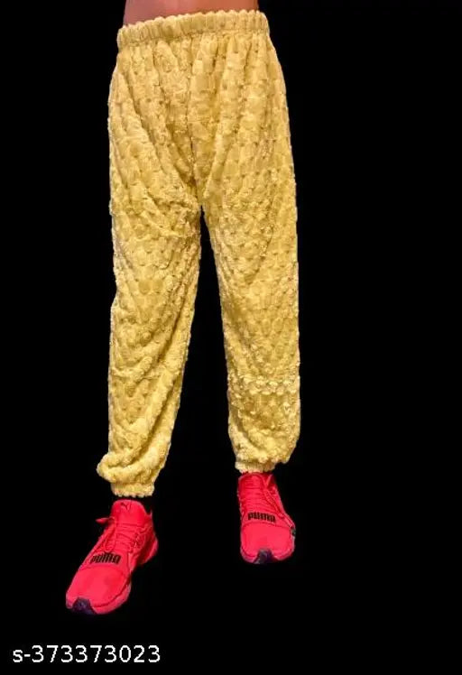 A person wearing yellow bottoms, posing against a dark background