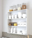 White wall hanging kitchen shelves with food items and jars
