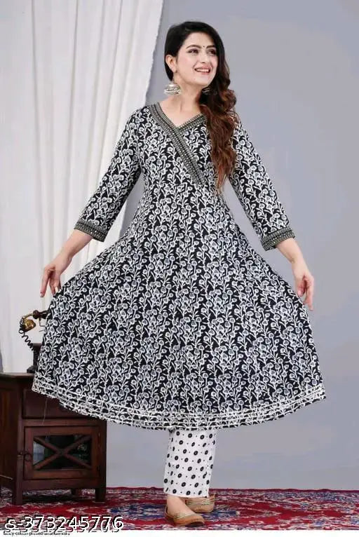 A woman in a black, patterned maxi dress with short sleeves and a fitted bodice