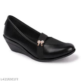 Black synthetic wedge-heeled loafers with metallic buckle and bow accents