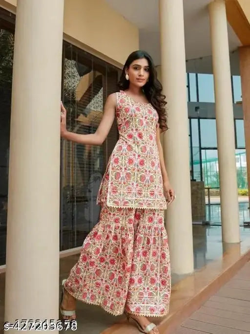 A woman posing in a traditional Indian outfit, possibly a lehenga or sari with intricate floral patterns, standing outdoors