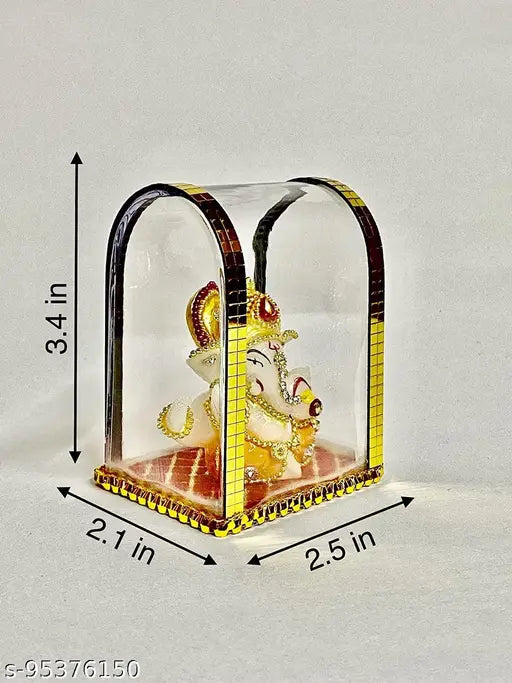 Black acrylic glass box with decorative border, housing a small Lord Ganesh idol figurine on a car dashboard