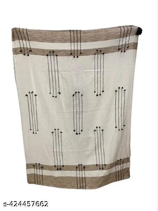 The image is of a beige, dobby throw with intricate patterns and a fringe at the bottom, showcasing its soft texture