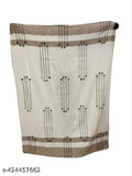 The image is of a beige, dobby throw with intricate patterns and a fringe at the bottom, showcasing its soft texture