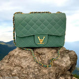 A sling bag in blue with a Pu leather texture and gold zippers, designed for women