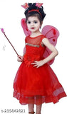 A child in a fairy costume with red tulle skirt, holding a wand