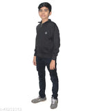 A young boy wearing a dark jacket, posing in front of a neutral background