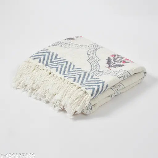 A multi-colored, patterned throw blanket on a white background