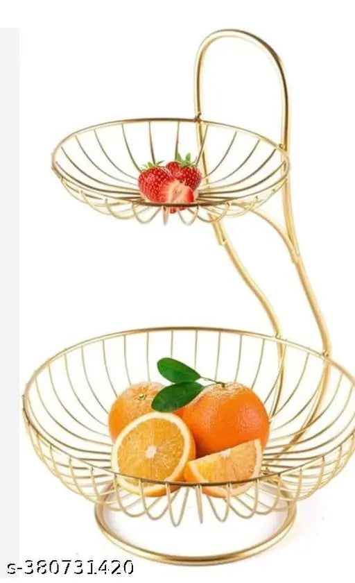 Two-tiered steel fruit basket with gold finish on dining table