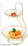 Two-tiered steel fruit basket with gold finish on dining table