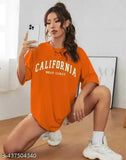 The image is of a woman taking a selfie. She's wearing an oversized round-neck t-shirt with the word "California" printed on it. The shirt has short sleeves, is light orange in color, and appears to be made from cotton material
