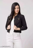 A woman wearing a black denim jacket with a dark shirt, white jeans, and her hair pulled back