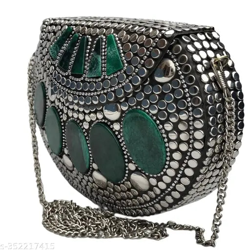 A silver metal hand clutch with green decorative stones