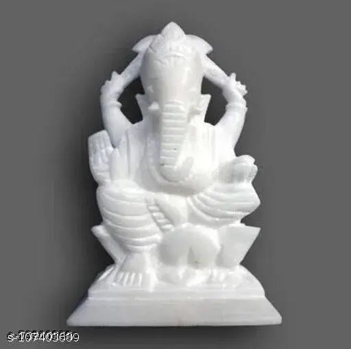 White marble Ganesh idol with multiple arms, seated on a lotus flower base