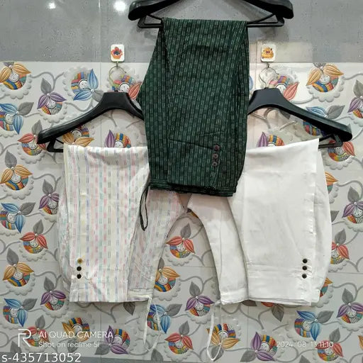 Blue and white cotton pants, green shirt set with white blouse, hanging on a rack
