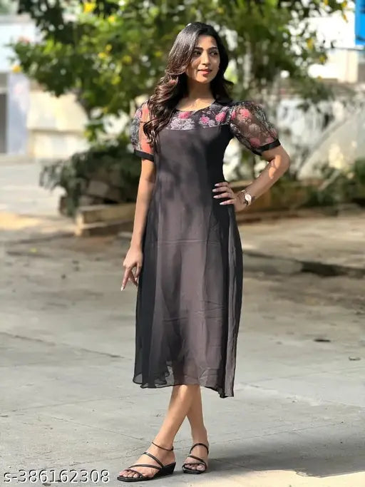 A stylish black kameez worn by a woman with black hair and black sandals