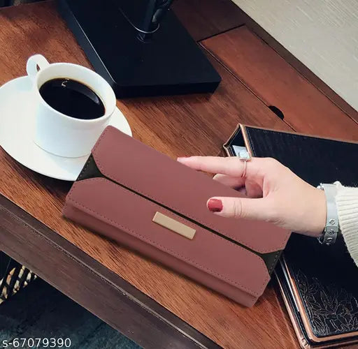 A lady is holding a unique clutch bag with an attached wallet and a snap closure, showing its contents, on a table