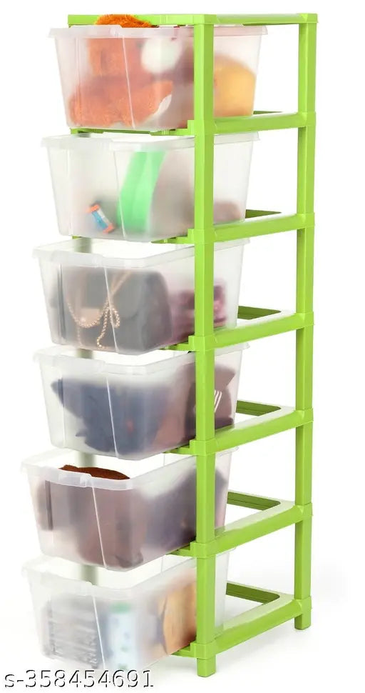 A green plastic drawer organizer with storage bins, stacked with various items including books and shoes