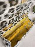 Stylized, black-and-white sling bag with gold zipper accents