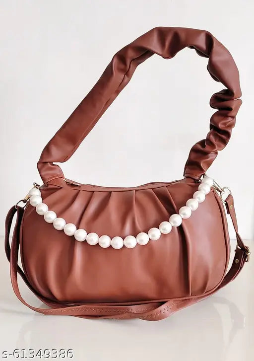 Brown leather handbag with pearls accents, featuring a detachable shoulder strap and a handle