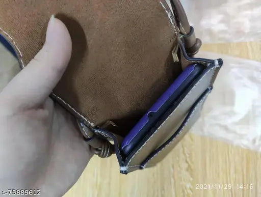 A brown leather cell phone sling bag with a blue interior