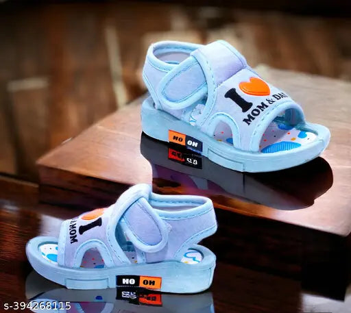 Light blue sandal with white straps and a small black heart on the front for toddlers