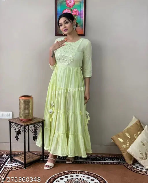 Yellow traditional attire with heavy embroidery on the yoke and border, worn by woman with embellished sleeves