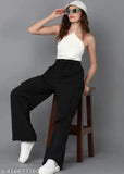 Black cargo pants with wide legs, pockets and drawstrings, sitting on a stool
