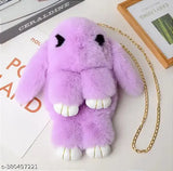 Purple plush toy resembling a cute rabbit character with long ears, wearing white teeth, hanging from a chain on a light-colored surface