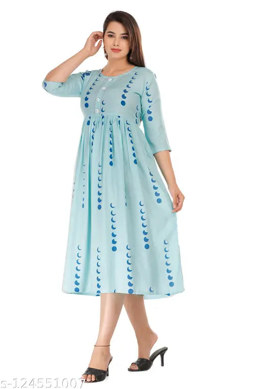 A woman wearing a light blue, long-sleeve, traditional rayon printed dress with decorative borders