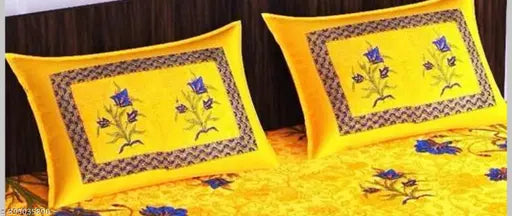 Yellow cotton bedsheet with floral design and decorative border.