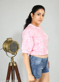 A woman in a pink t-shirt with denim shorts