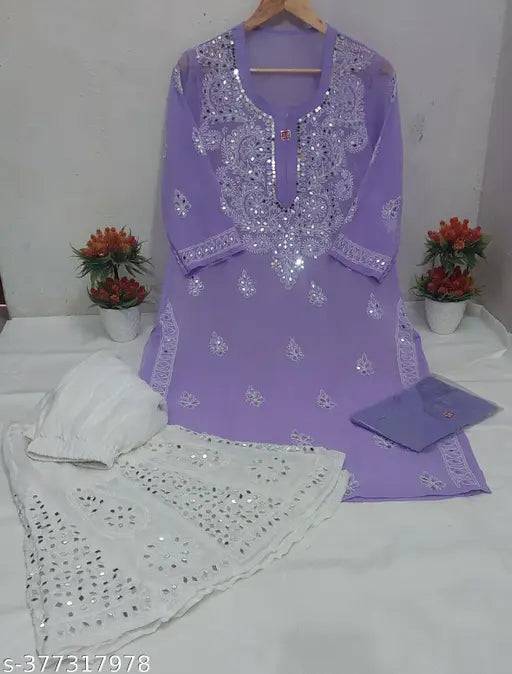The image depicts a traditional Luckhnowi women's outfit, featuring a long chiffon kurta in shades of purple, adorned with intricate mirror work and detailed embroidery on both the inner style and the outer kurta. The ensemble is paired with matching sharara bottoms and inner styles, showcasing an elegant and feminine attire