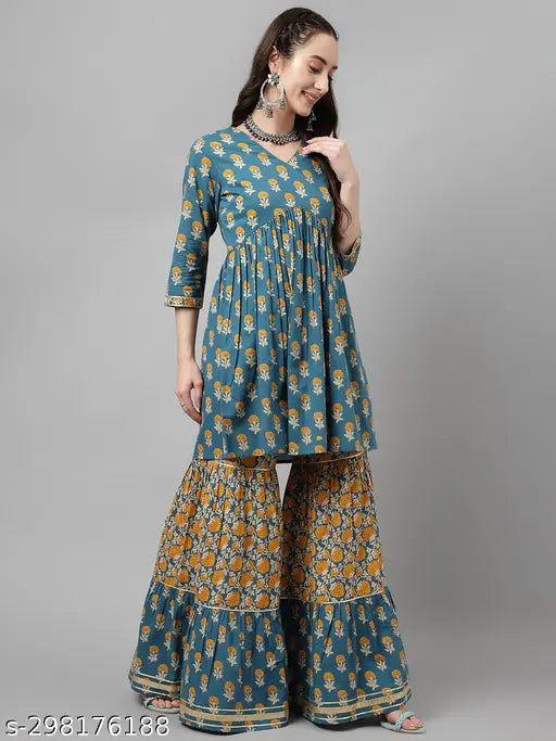A peach colored flared kurta on a woman, featuring sharpas and a dupatta
