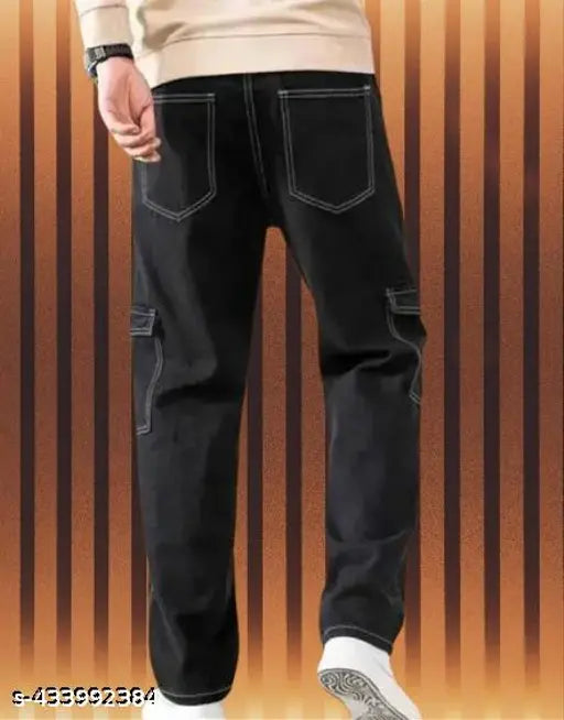 A person in a dark setting is wearing black men's cargo pants with 6 pockets. The pants are made of what appears to be a woven fabric, possibly cotton or denim, and have a classic design with two front pockets and four side pockets. There are no visible brand names or closure types in the image