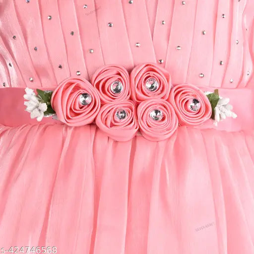 Pink satin pleated knee-length party dress with silver kraft detailing, 2 ruffle embellishments at chest level, fitted belt sash, and adorned with multiple silver embellishments
