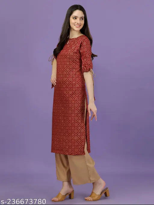 Maroon rayon kurta and palazzo set with all-over gold print, keyhole neck, three-quarter sleeves, tie-up and tassels. Made in India