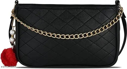Black leather sling bag with red tassel accents and a gold chain strap