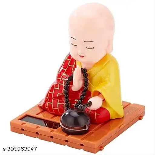 Multicolor solar-powered moving Gautam Buddha statue, plastic, 11cm height. Indoor/car decor item promoting peace & mindfulness. Eco-friendly solar technology. Made in India