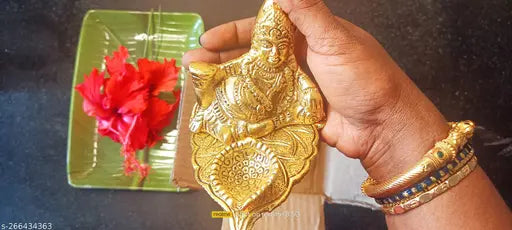 Diwali lamp with a gold base, lit, holding a red flower